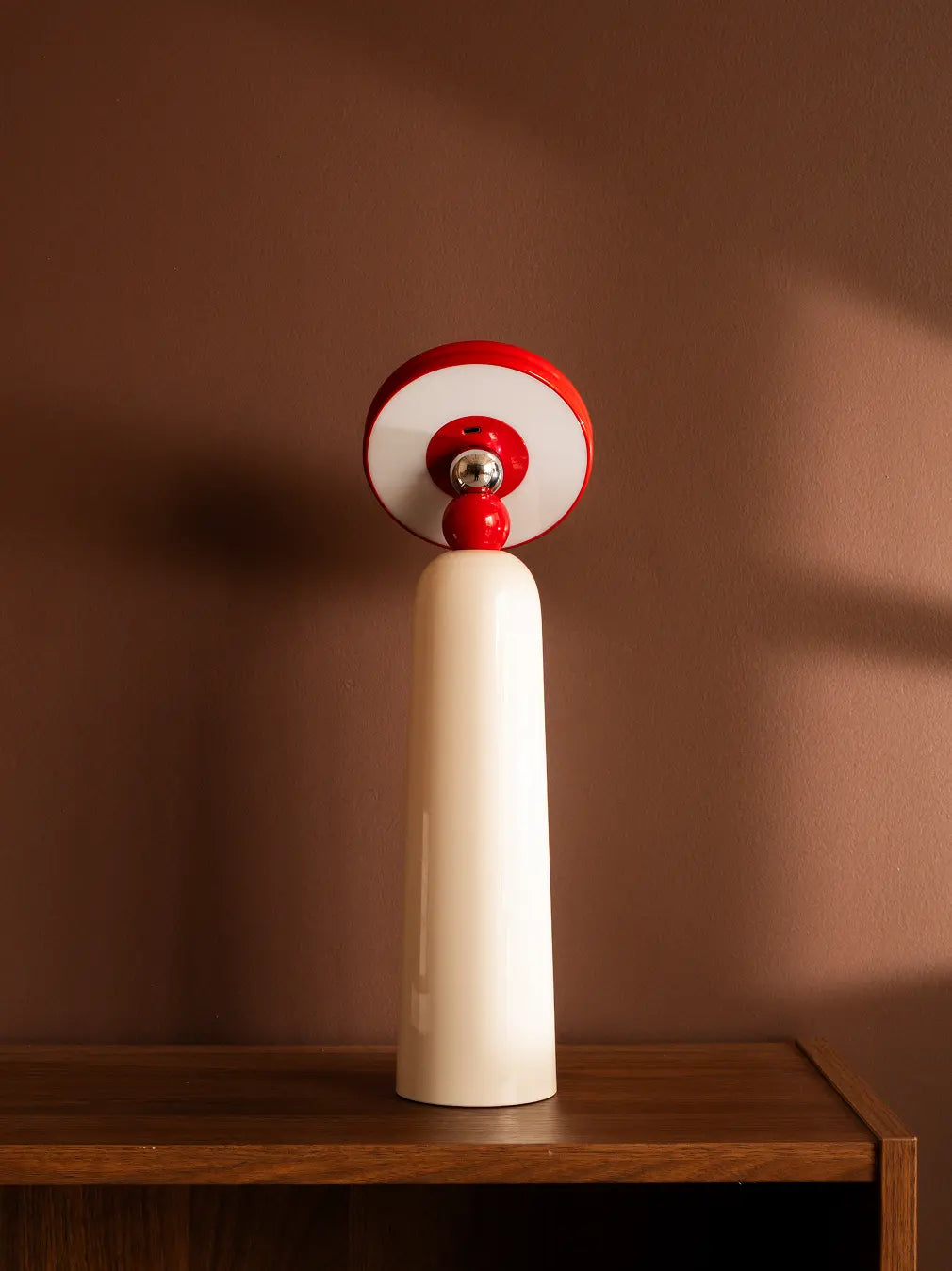 Gharko 3-in-1 Frisbee Retractable Lamp in table mode on wooden shelf, warm modern home decor lighting.