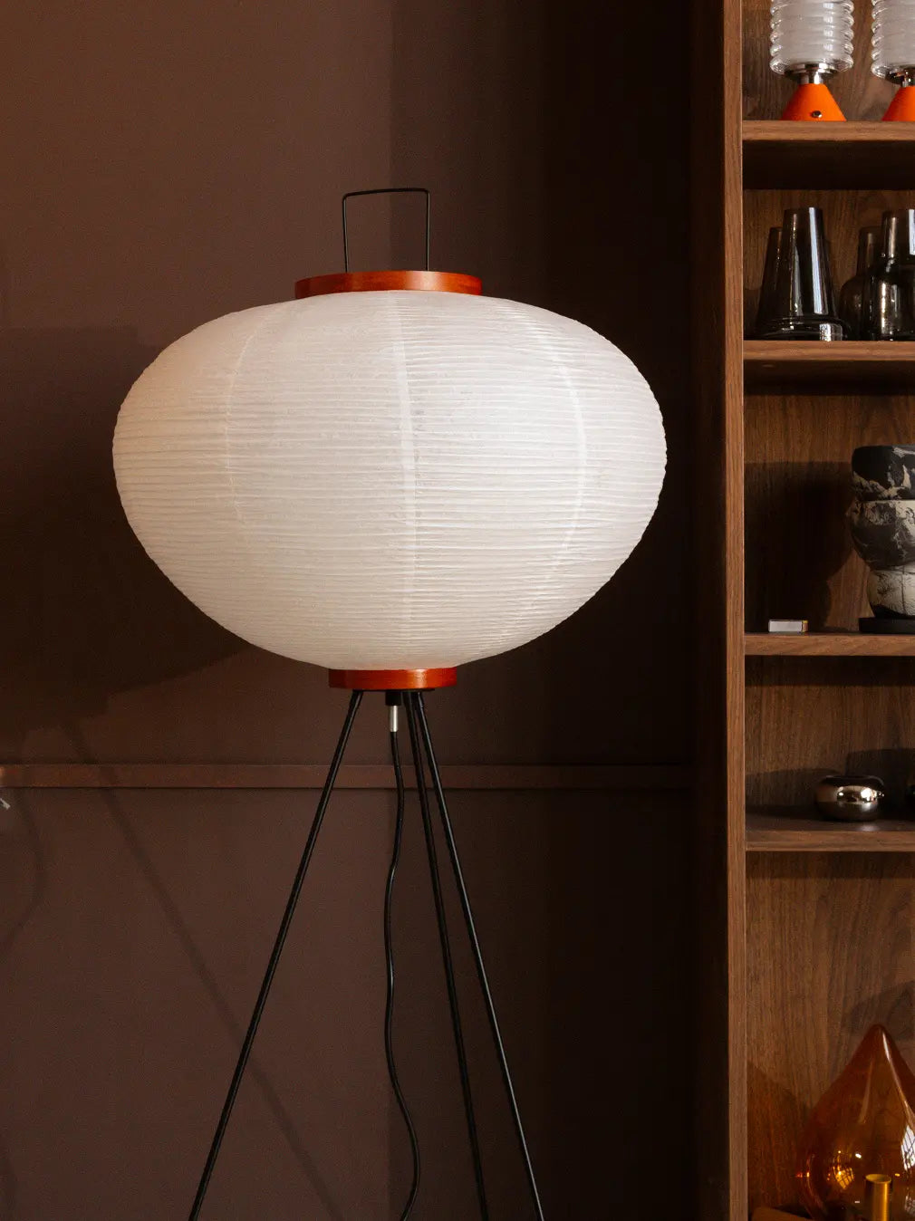 White Akari Japanese Rice Paper Floor Lamp with wooden accents styled against a brown modern interior.