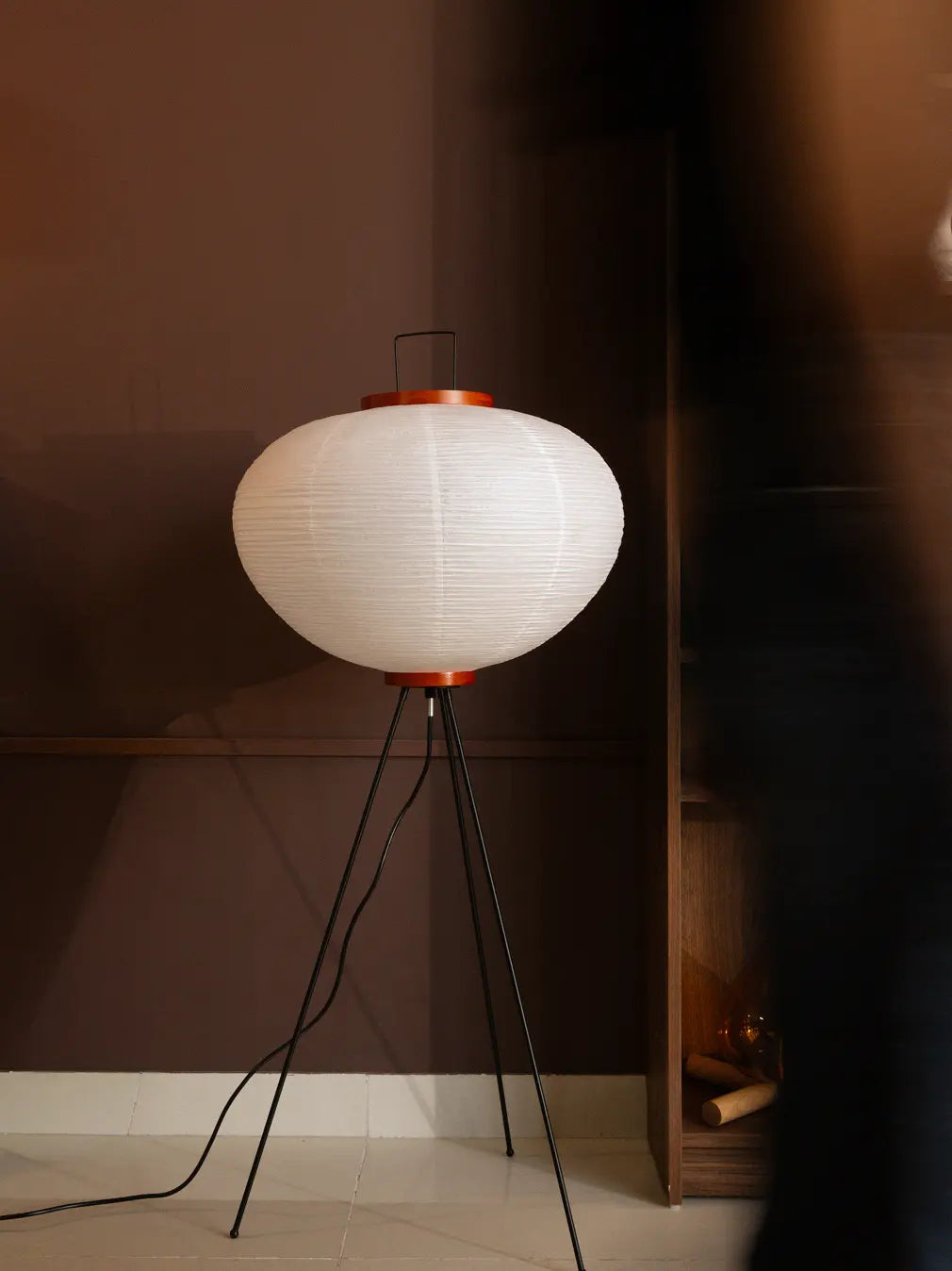 White Akari Japanese Rice Paper Floor Lamp on tripod base placed in a minimalist Japandi style room.