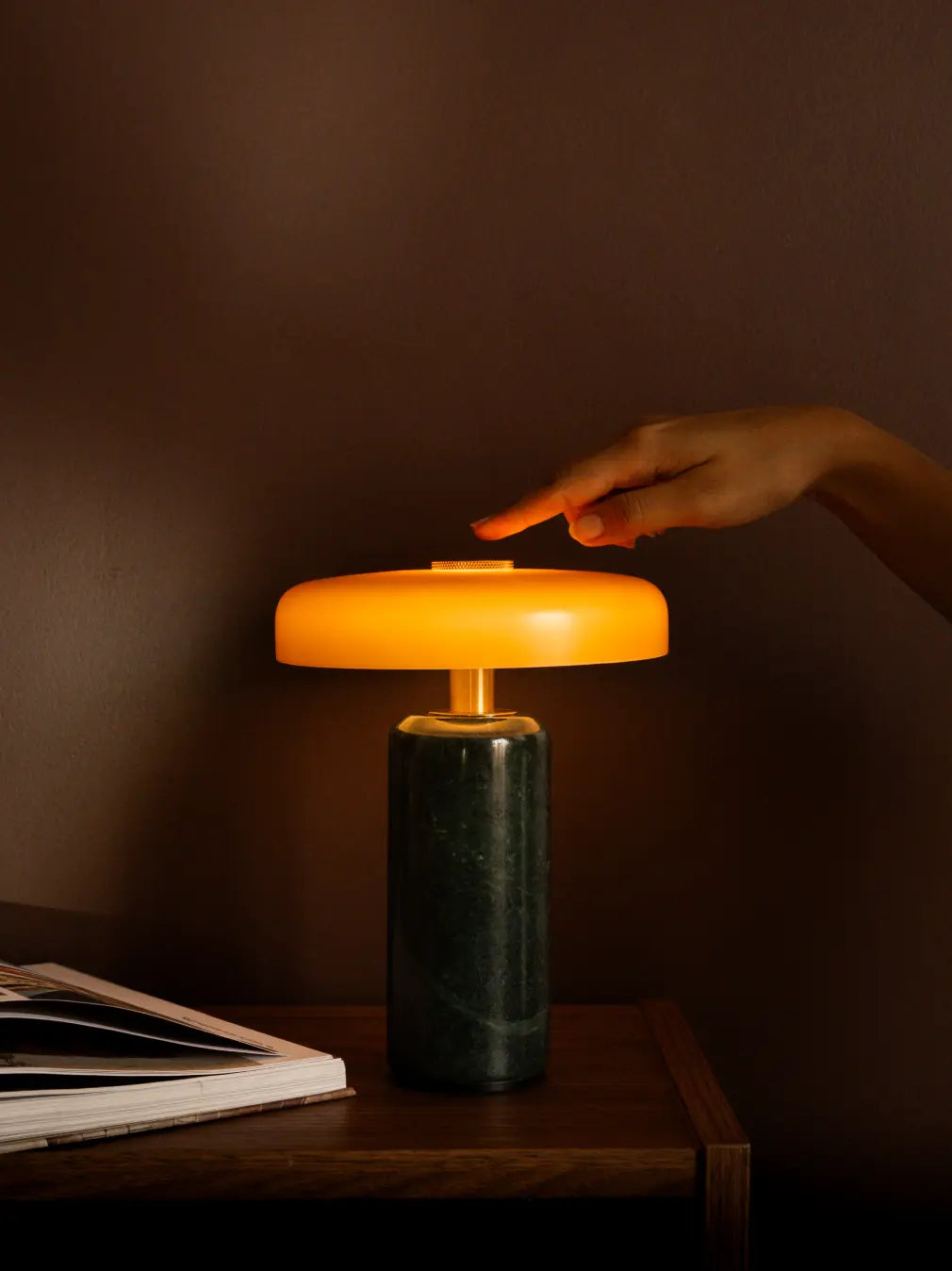 A person using the Alba Moss Marble Table Lamp with touch control for warm ambient lighting