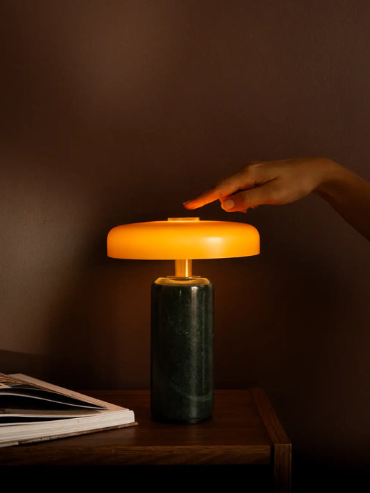 A person using the Alba Moss Marble Table Lamp with touch control for warm ambient lighting