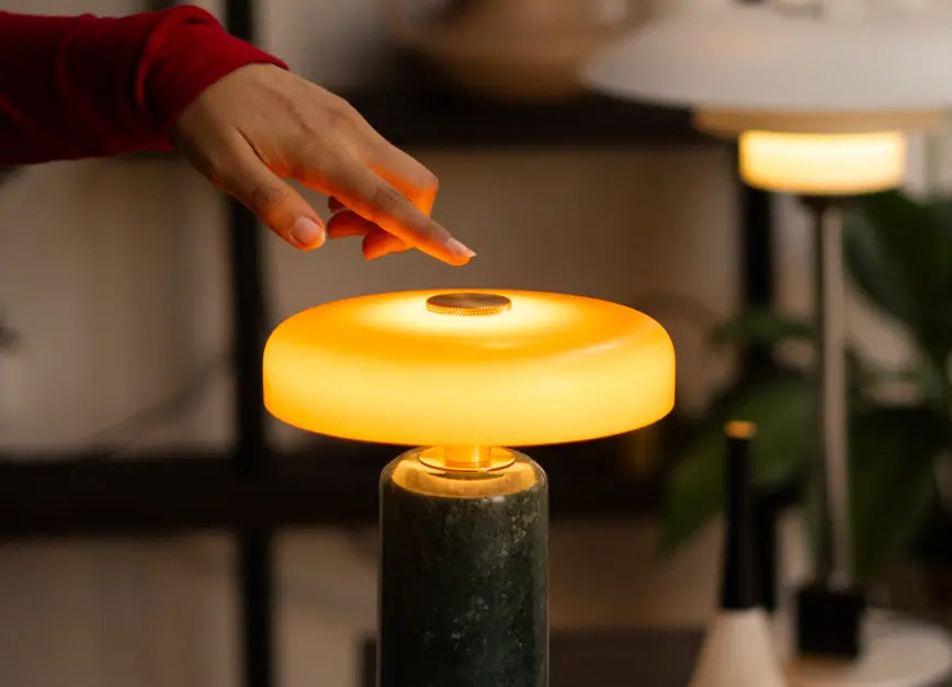 Touch control feature shown on the Alba Moss Marble Table Lamp with warm amber glow
