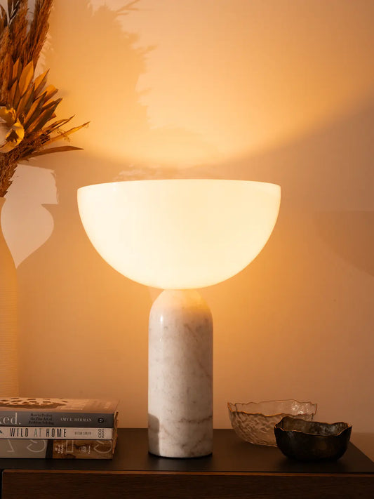 Arc Marble Table Lamp with white marble base and glossy glass shade on a console