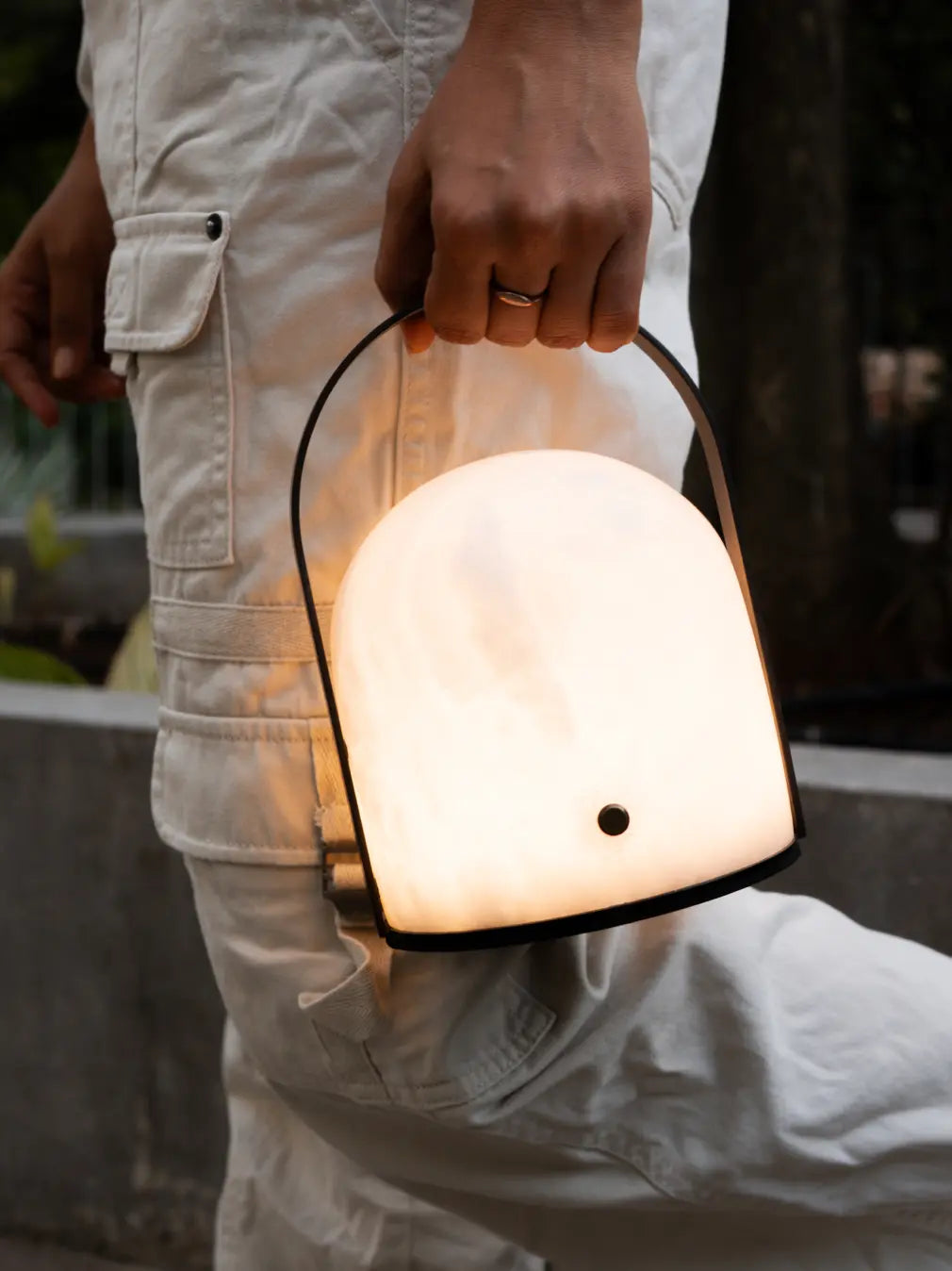 Arcus marble portable table lamp carried by its arched metal handle