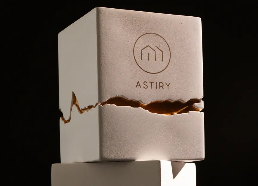 Stacked Astiry Concrete Scented Candles with a gold-filled cracked design, set against a dark background.