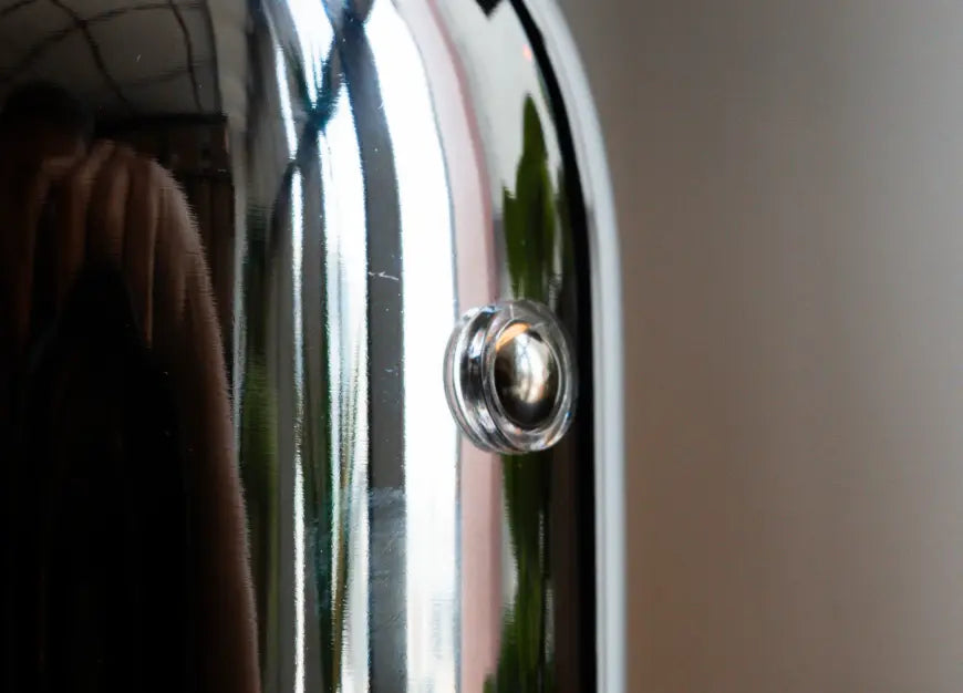 Close-up of chrome table lamp touch switch and metal finish