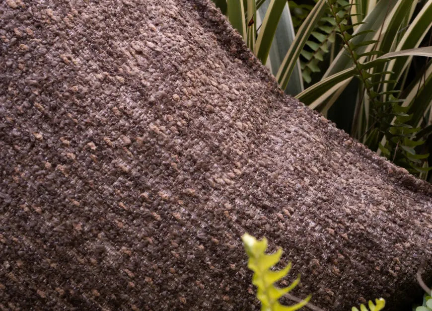 Close-up of boucle cushion cover showing dense jacquard weave and textured fabric