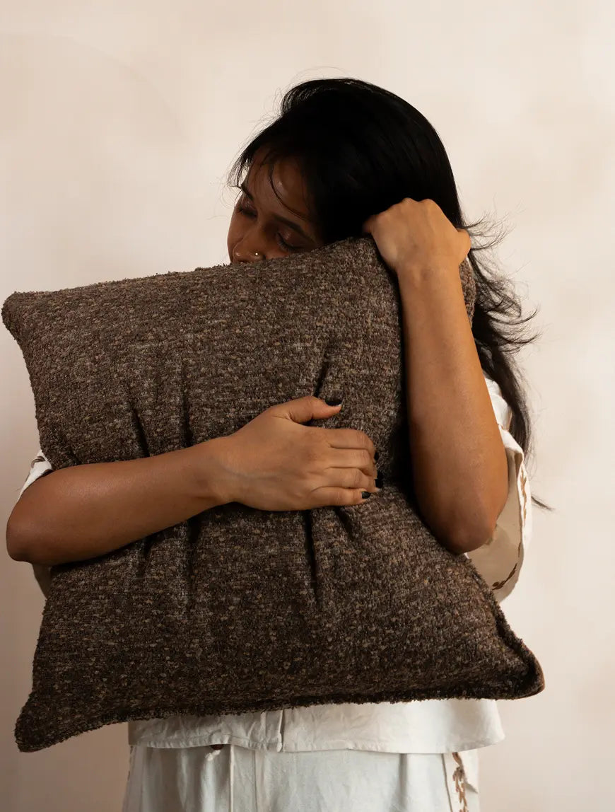 Boucle cushion cover hugged to show soft yet structured comfort and cozy feel