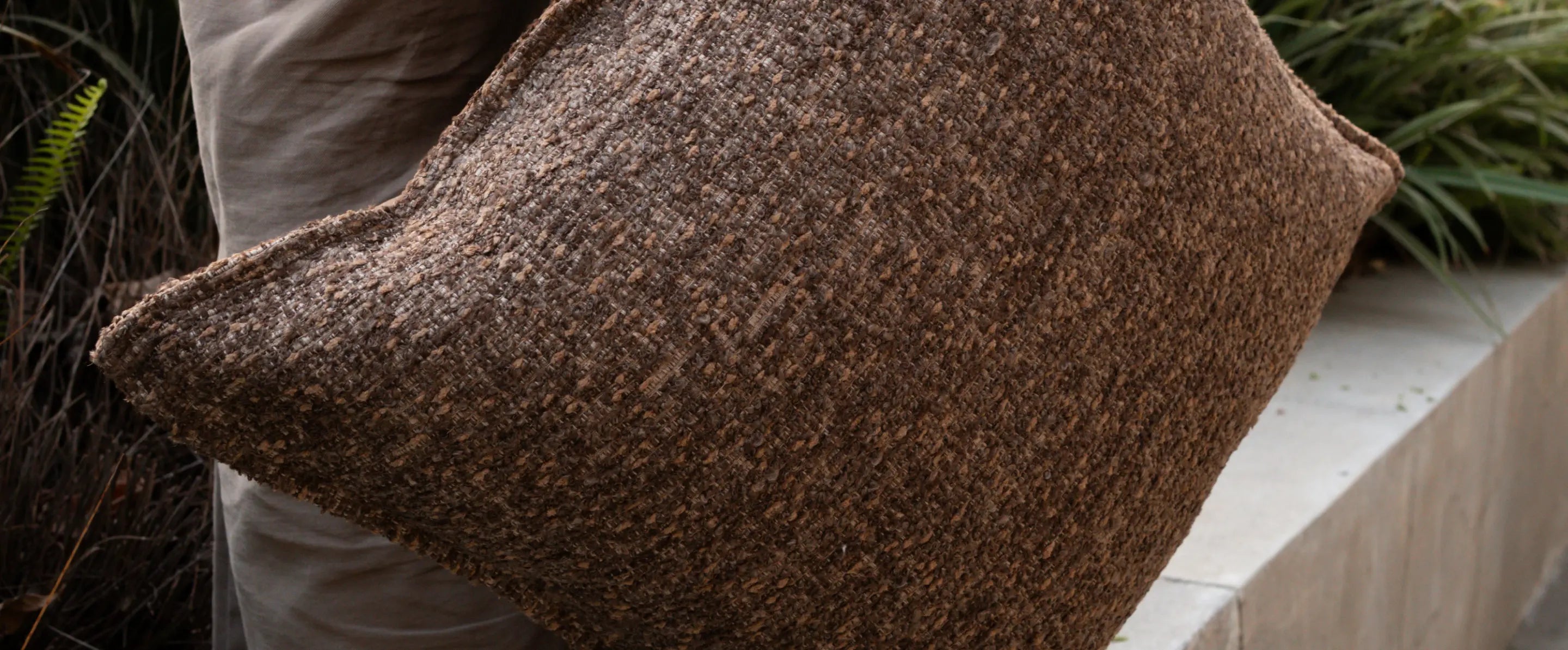 Side angle of boucle cushion cover with insert displaying thick texture and shape retention