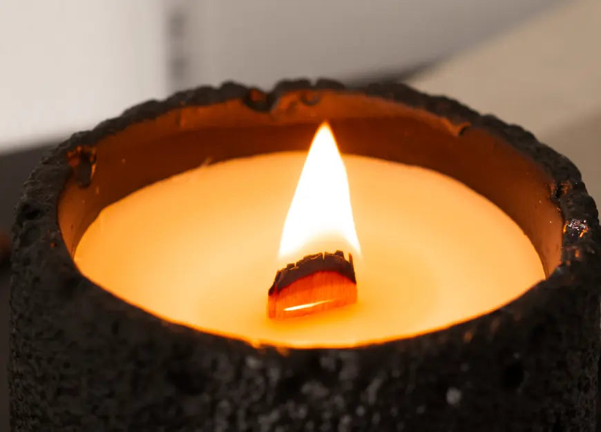 Close-up of burning wooden wick in black Capri candle with even wax melt pool