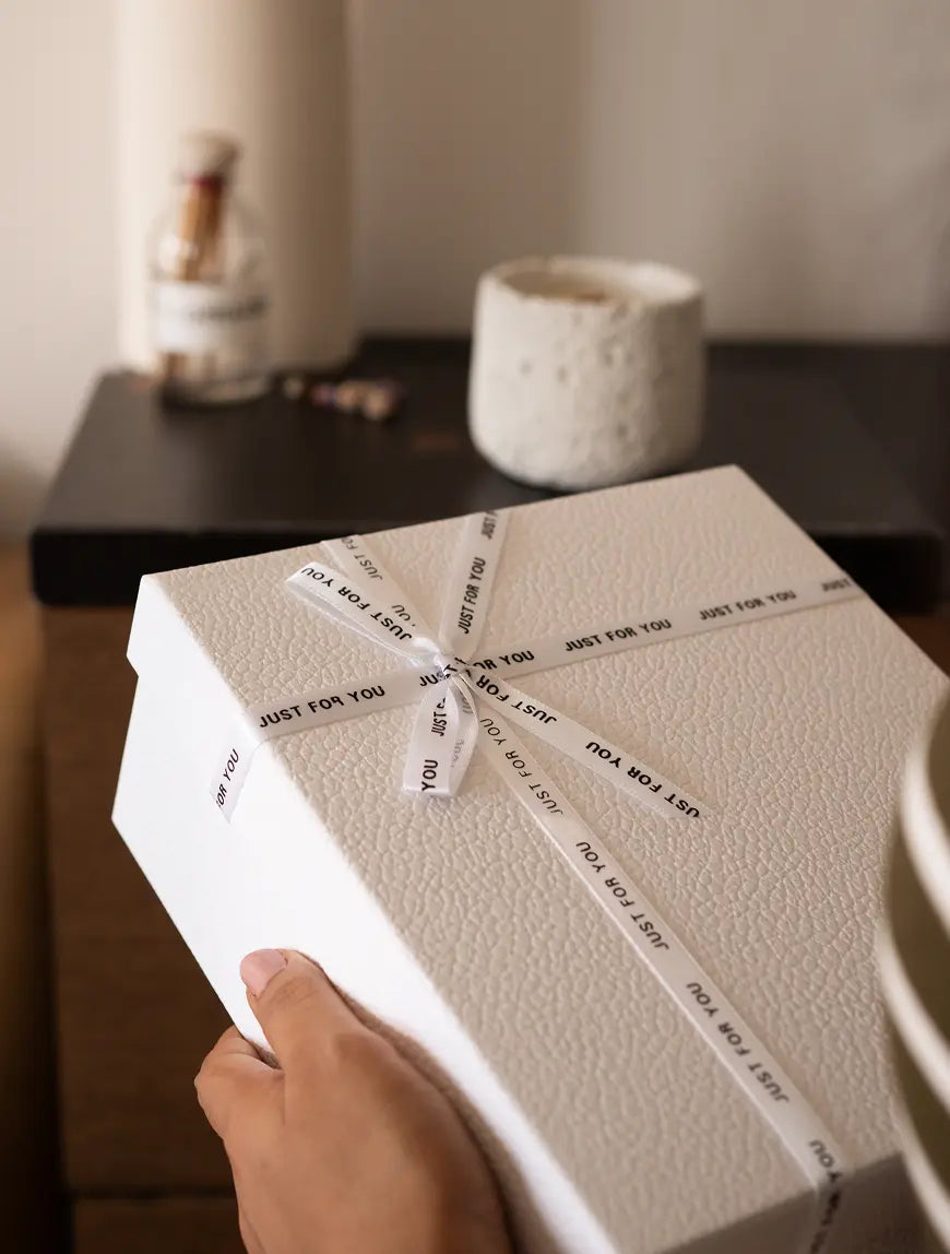 Premium gift box with Capri white candle and glass jar of matchsticks on dark tabletop