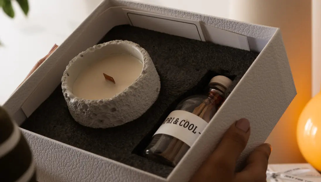 Open gift packaging of Capri Candle with foam insert, matchstick bottle, and card