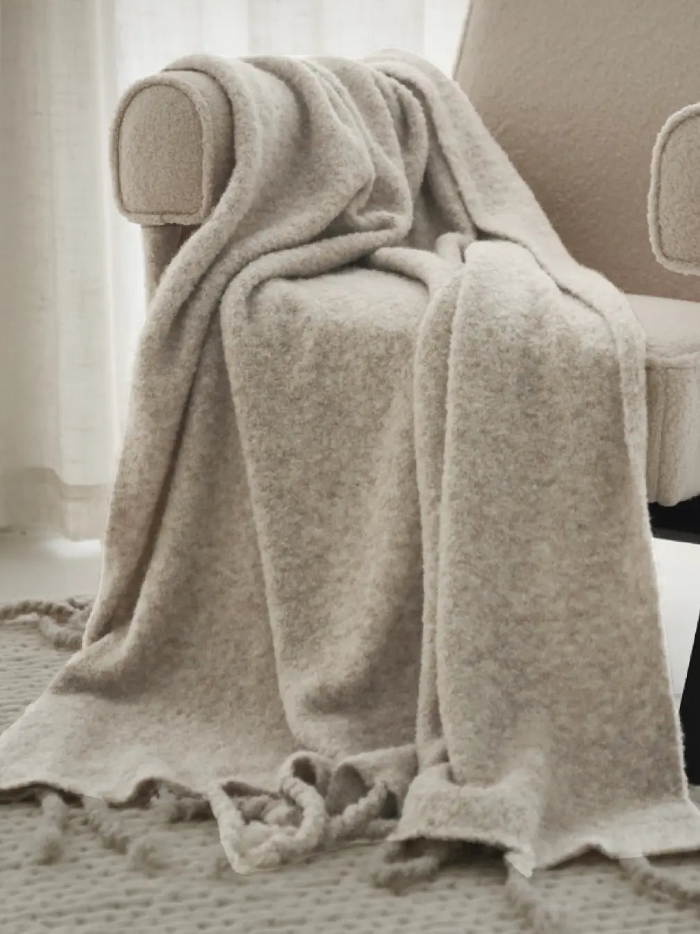 Cloudsoft apricot grey wool throw draped on armchair with soft tassel detailing