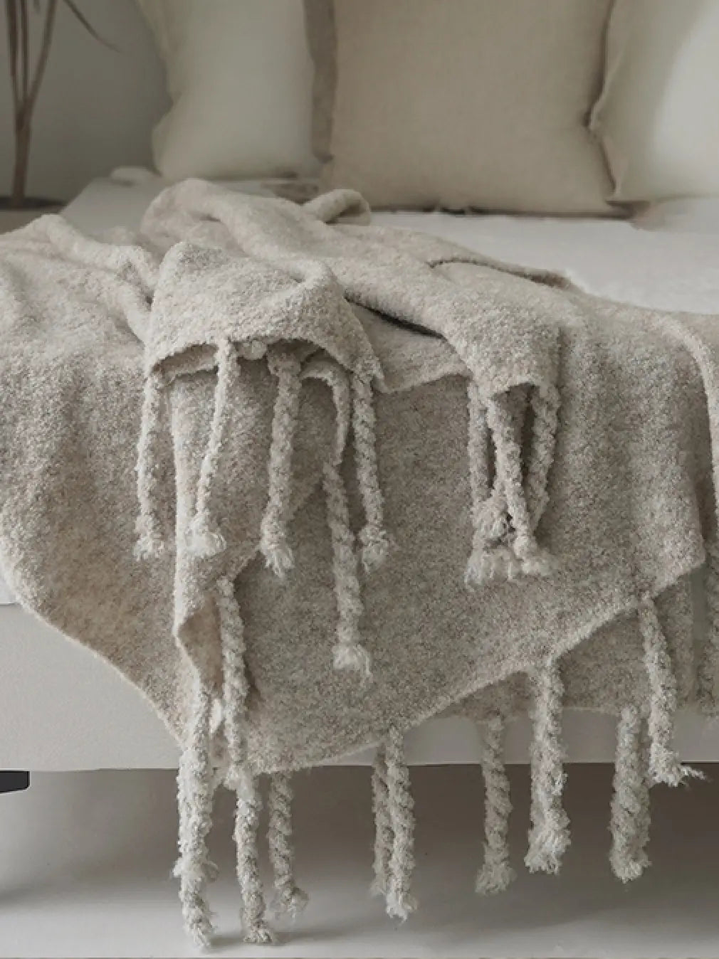 Extra-soft wool throw blanket styled on bed in apricot grey for cozy bedroom decor