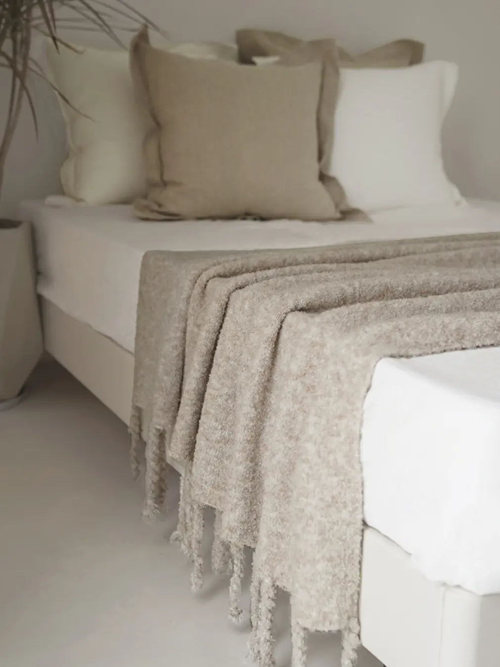 Premium knit wool throw layered on bed showcasing calm apricot grey texture