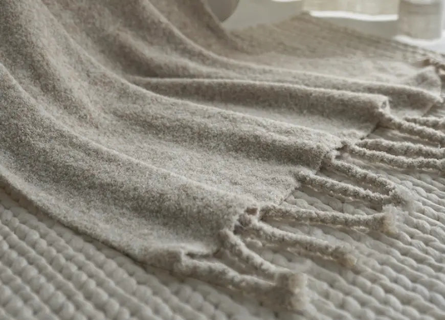 Apricot grey wool throw blanket with tassels styled on bed for calm home decor