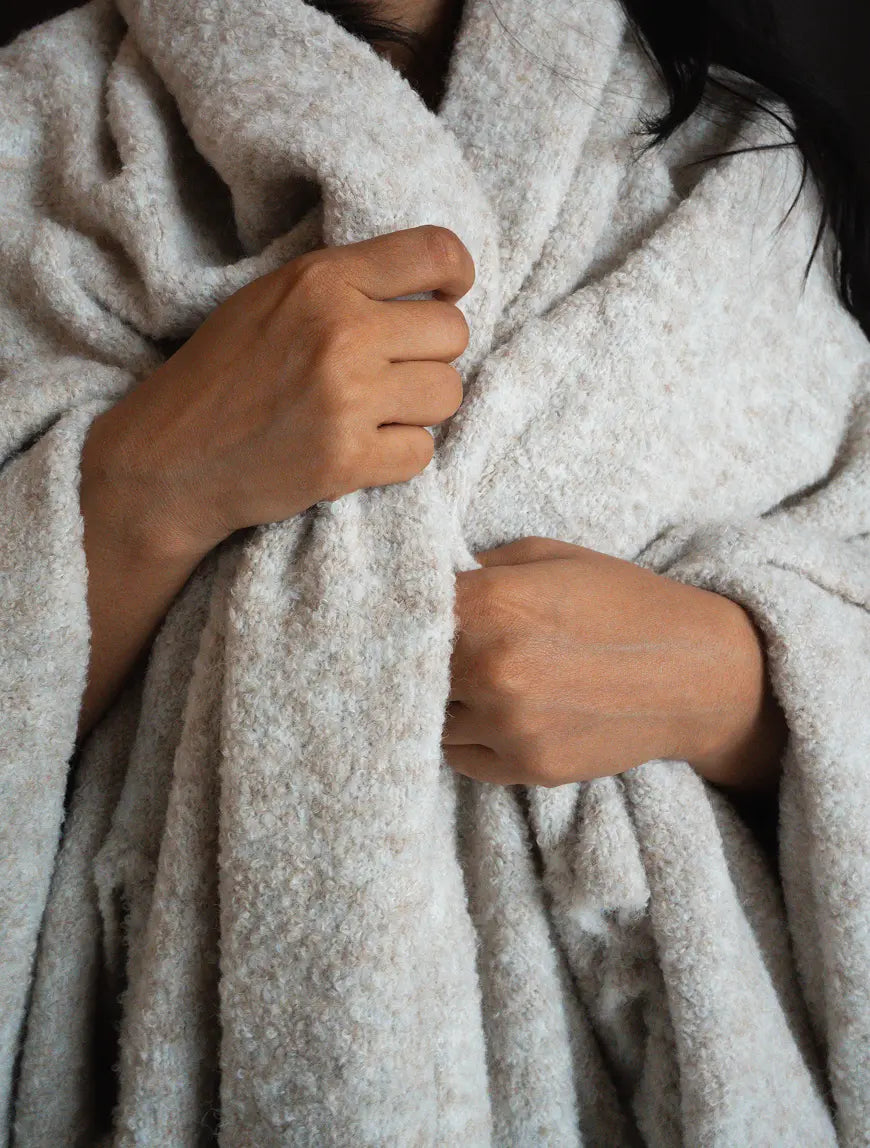 Extra-soft wool throw wrapped around shoulders for warmth and everyday comfort