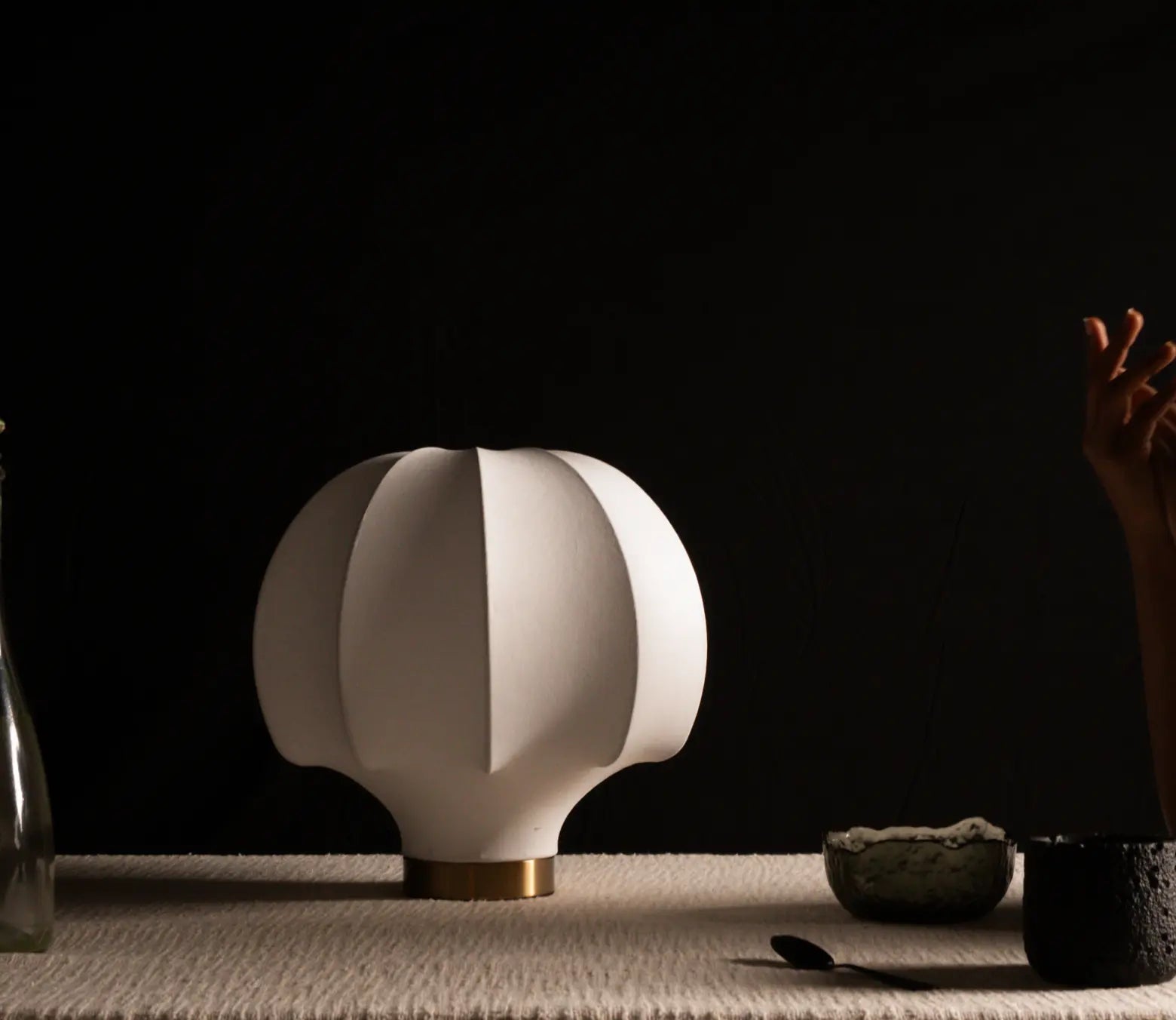 Modern white silk table lamp on a table with a dark background