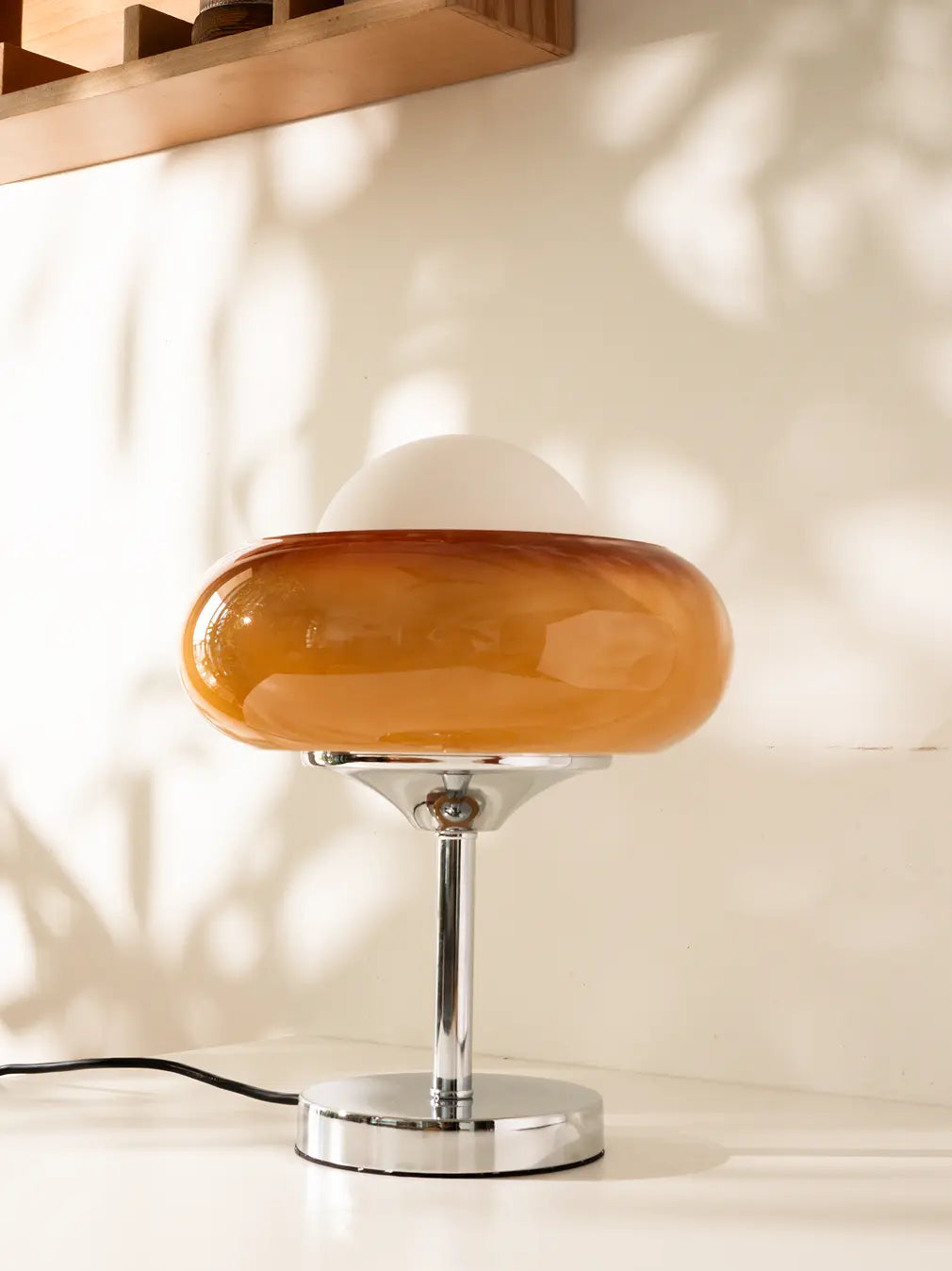 Table lamp with amber glass shade on a neutral background