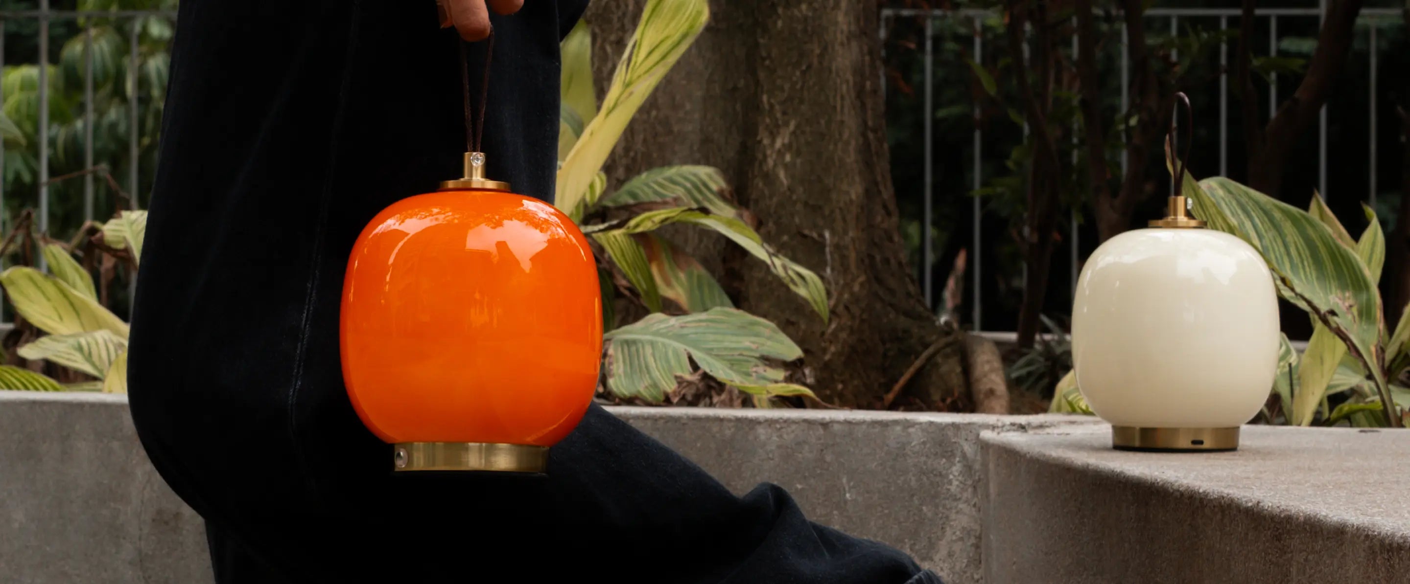 Orange and warm white Dew portable glass table lamps styled outdoors