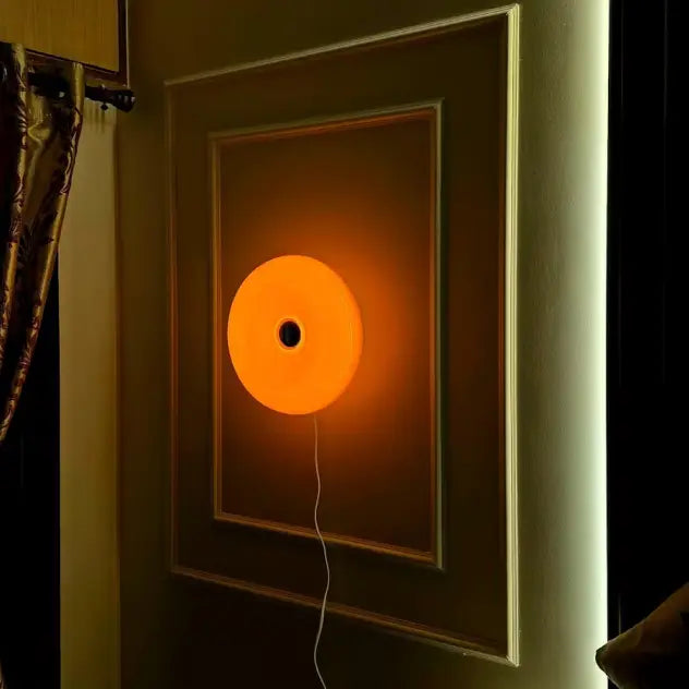 Wall-mount Donut orange lamp on a wall