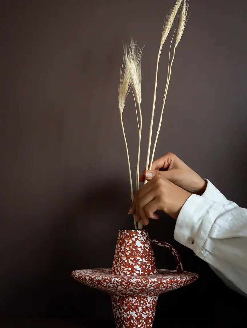 Ferro Base ceramic vase styled with dried stems and sculptural disc design