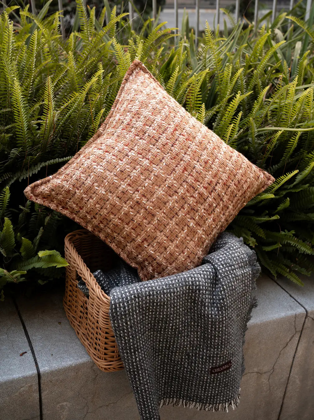 Brown Fleck cushion cover styled with plants and throws for a cozy home look.