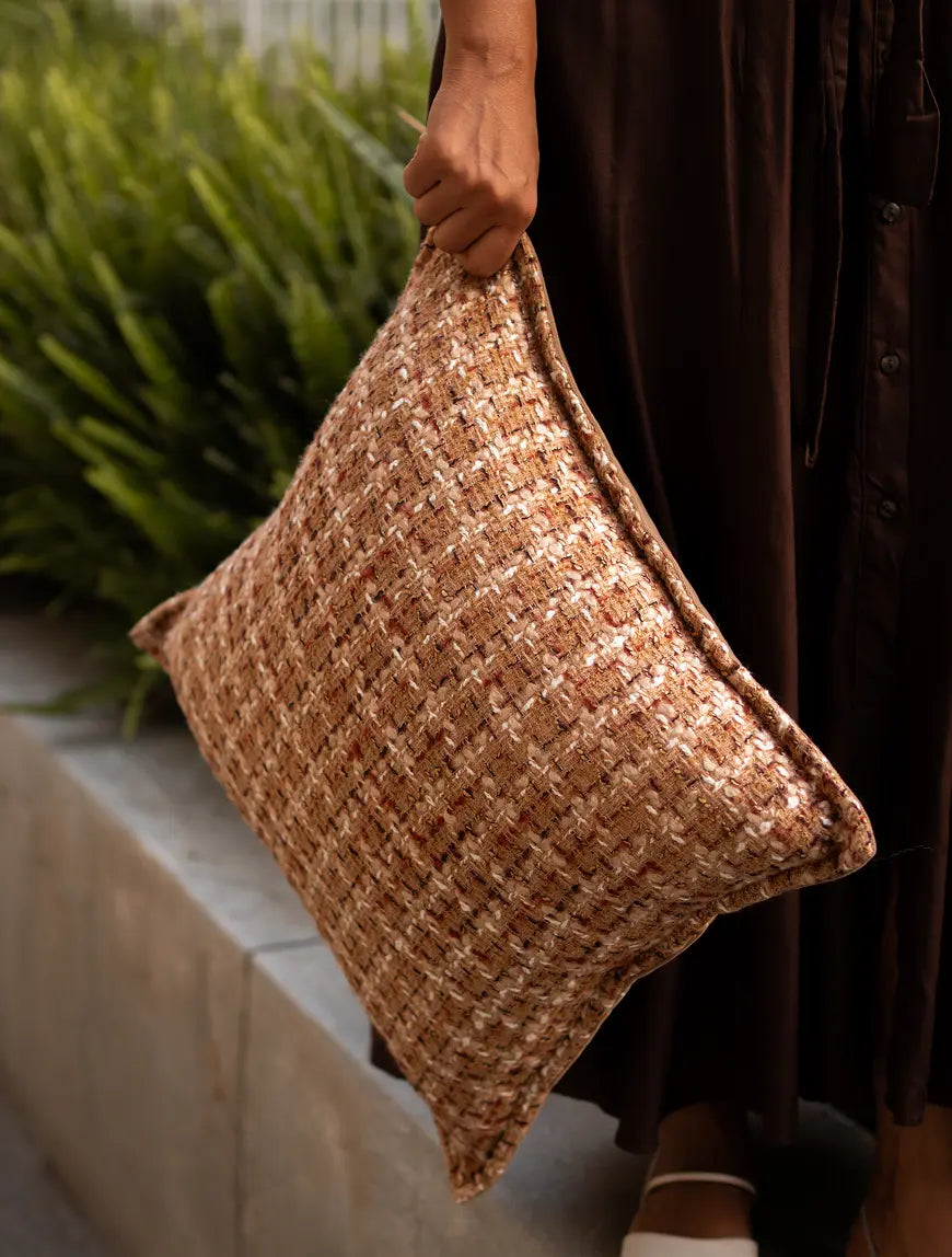 Fleck cushion cover styled on sofa, adding warmth and earthy comfort.