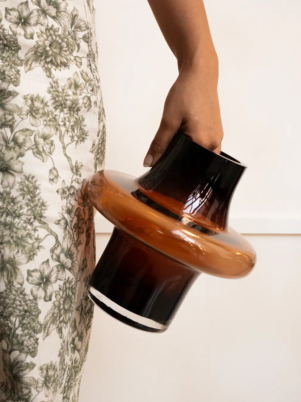 Person holding Halo Amber Glass Vase Small, modern amber glass vase with sculptural halo shape.