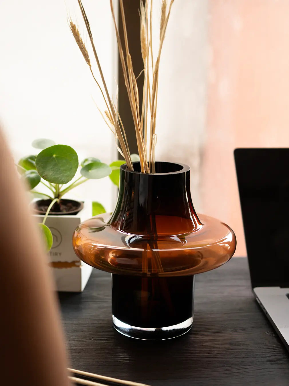 Person holding Halo Amber Glass Vase Small, modern amber glass vase with sculptural halo shape.