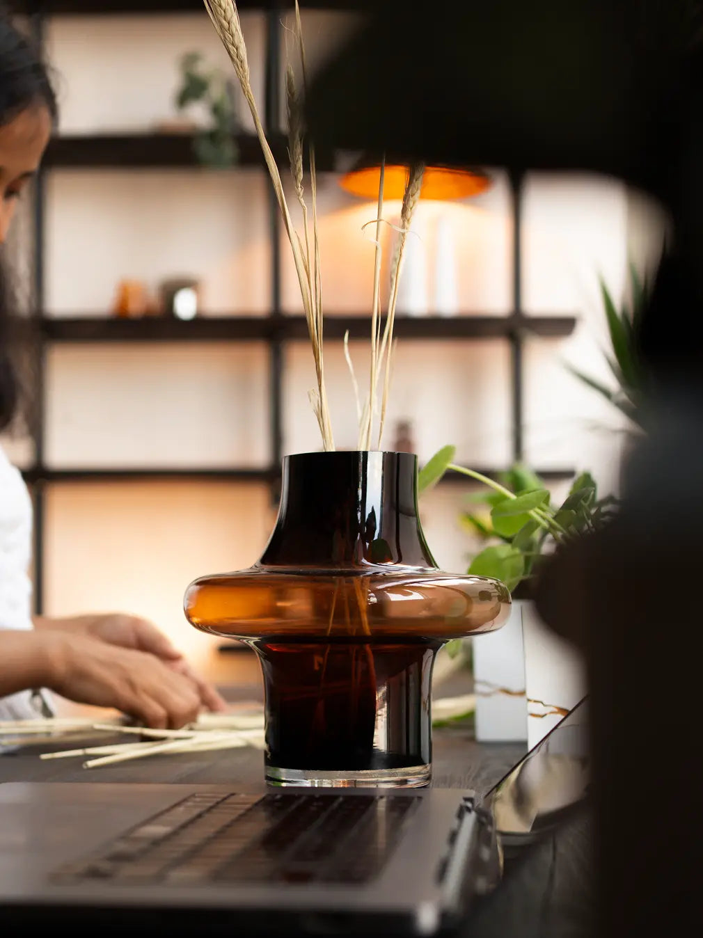 Person holding Halo Amber Glass Vase Small, modern amber glass vase with sculptural halo shape.