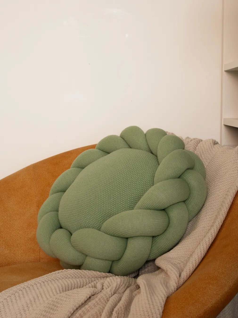 Halo Nest Cushion in Light green on chair – Gharko knitted round cushion