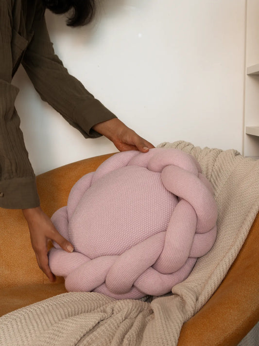 Placing Gharko Halo Nest Cushion in pink on a cozy tan chair