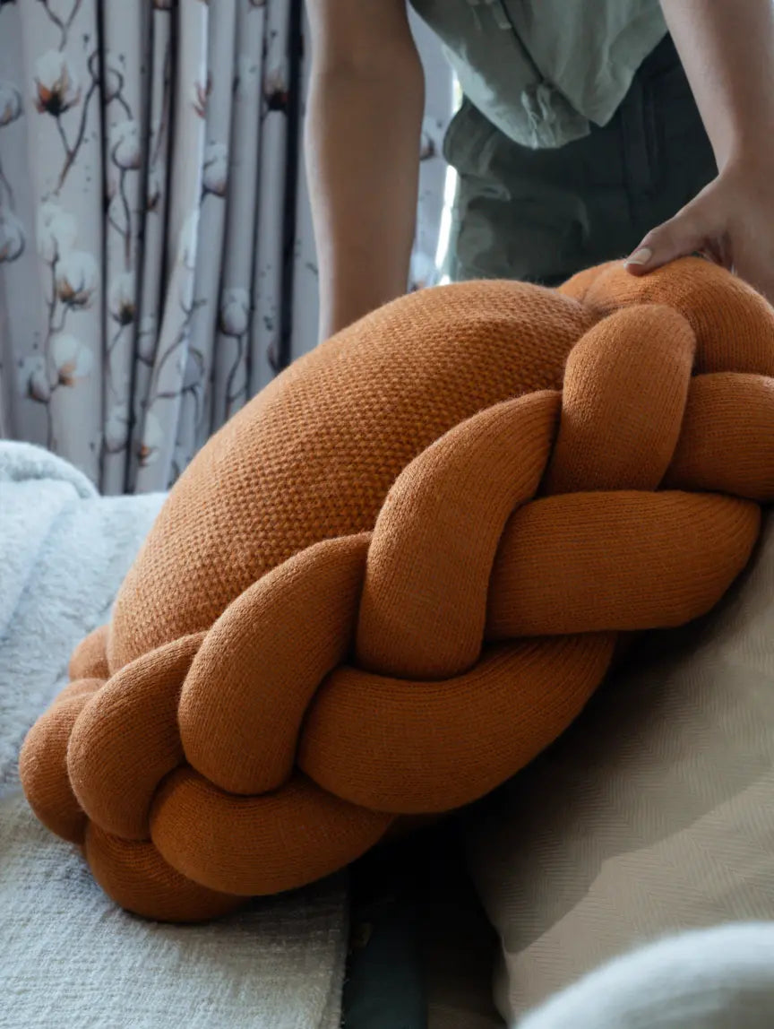 Halo Nest Cushion mustard round wool cushion with braided knit design styled on bed