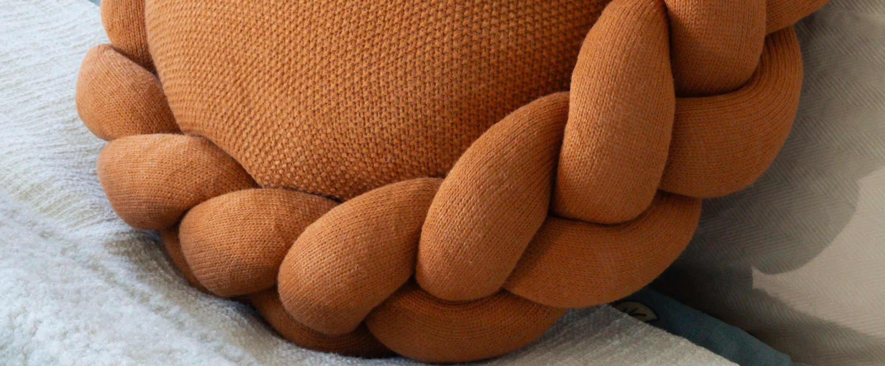 Round mustard cushion styled on sofa showcasing sculptural form and cozy home decor