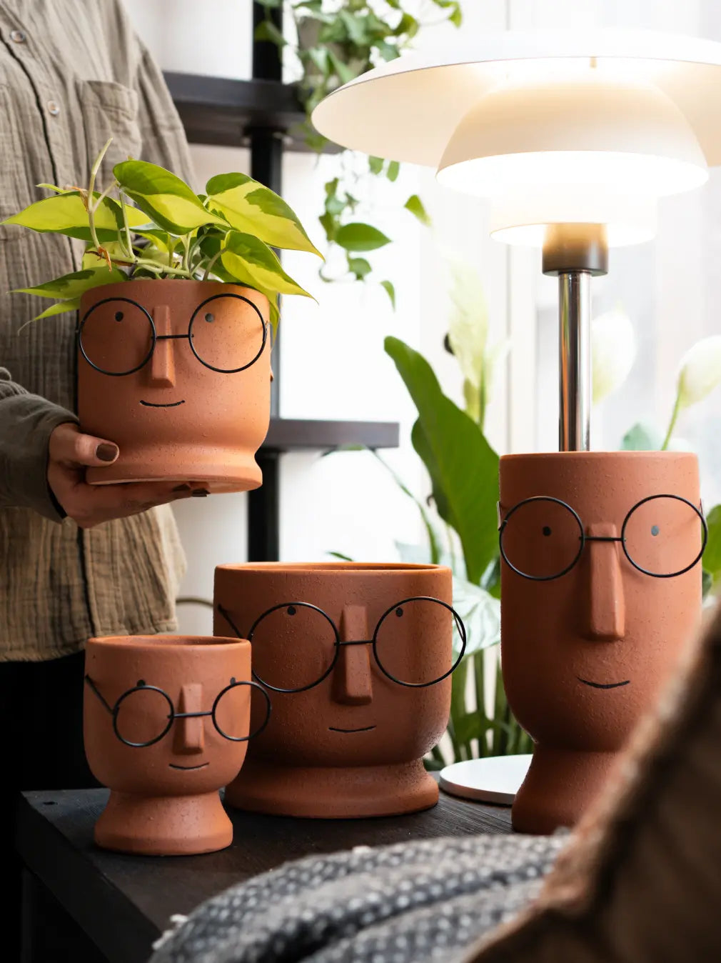 Jojo Brown Ceramic Planter in four sizes with playful face design, styled with indoor green plant