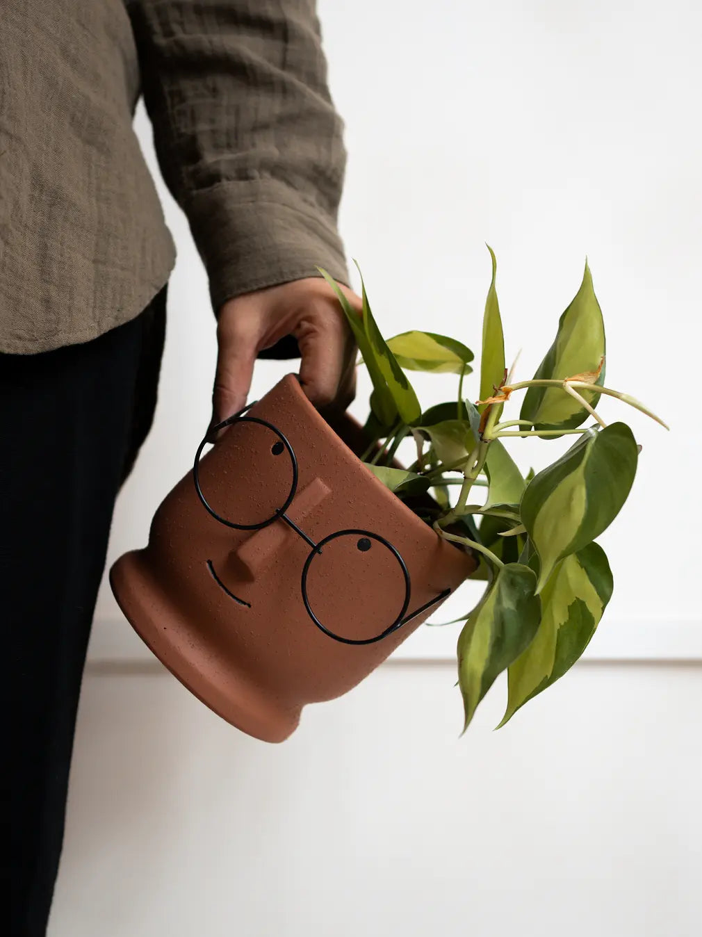 Close-up of Jojo Brown ceramic planter showing grainy texture and sculpted face detail