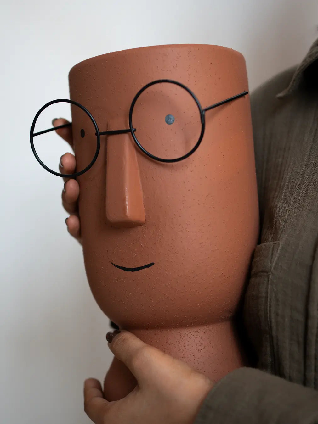 Handcrafted Jojo Brown ceramic indoor planter highlighting minimal face and metal glasses