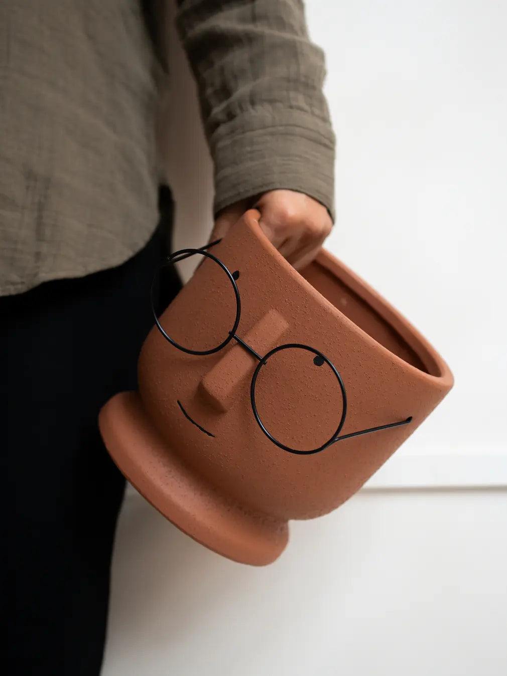 Jojo Brown ceramic planter held in hand, showcasing its design and texture