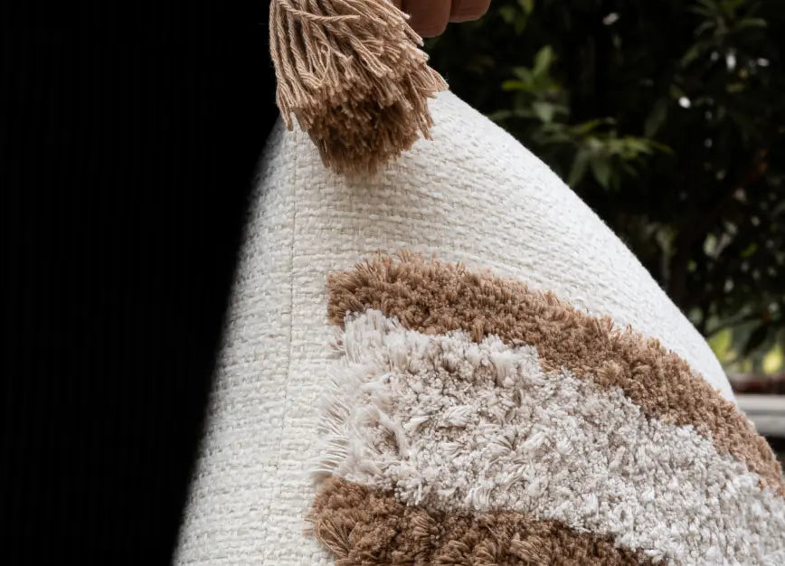 Side view of Kanso cushion cover highlighting tassel detail and textured fabric