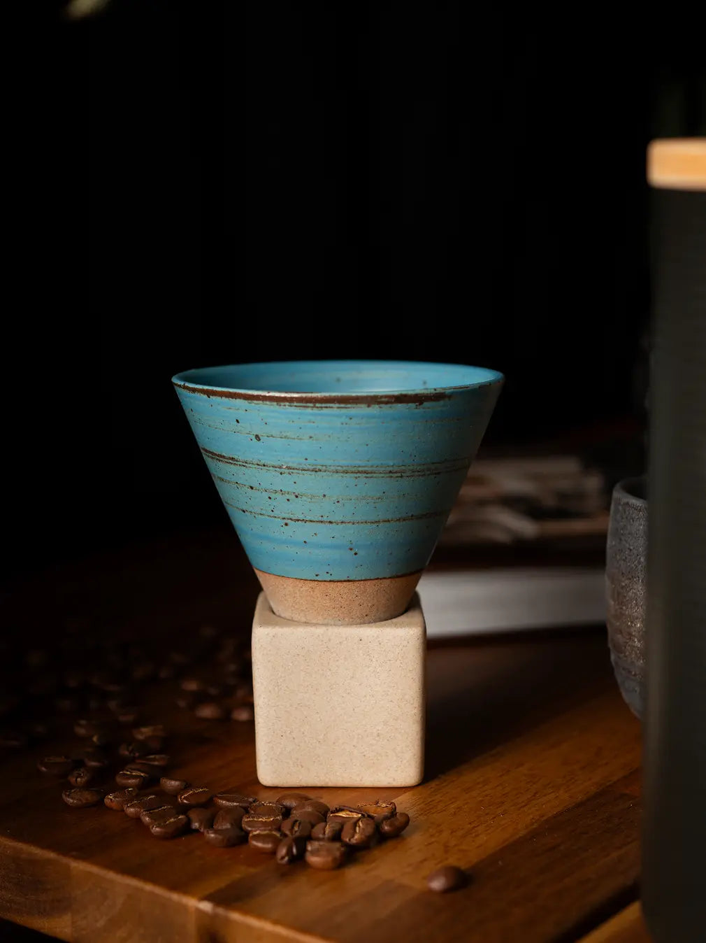 Kono ceramic coffee cup in blue with sculpted cone design on wooden surface