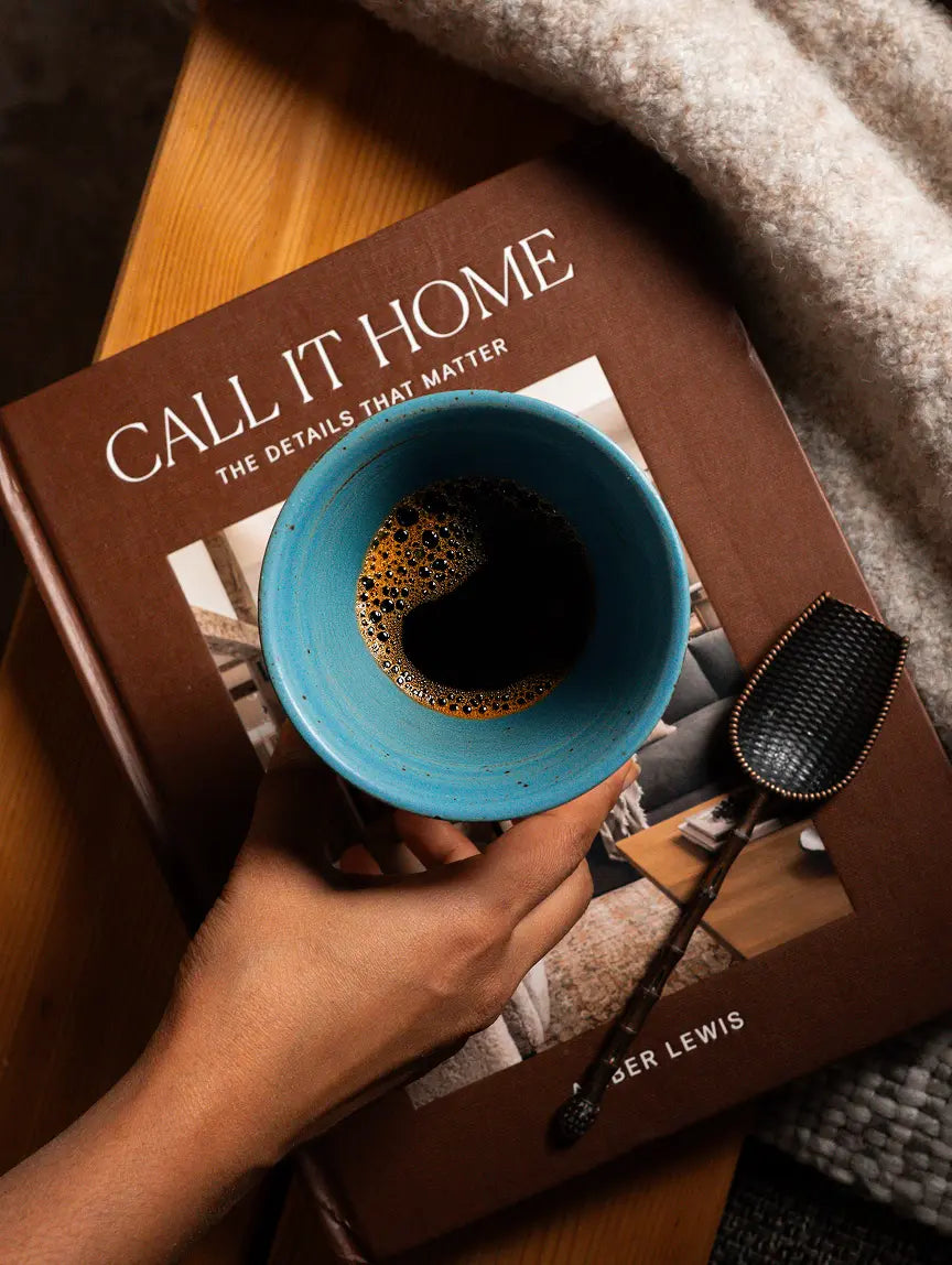 Top view of turquoise ceramic coffee cup with rich brew on a lifestyle book