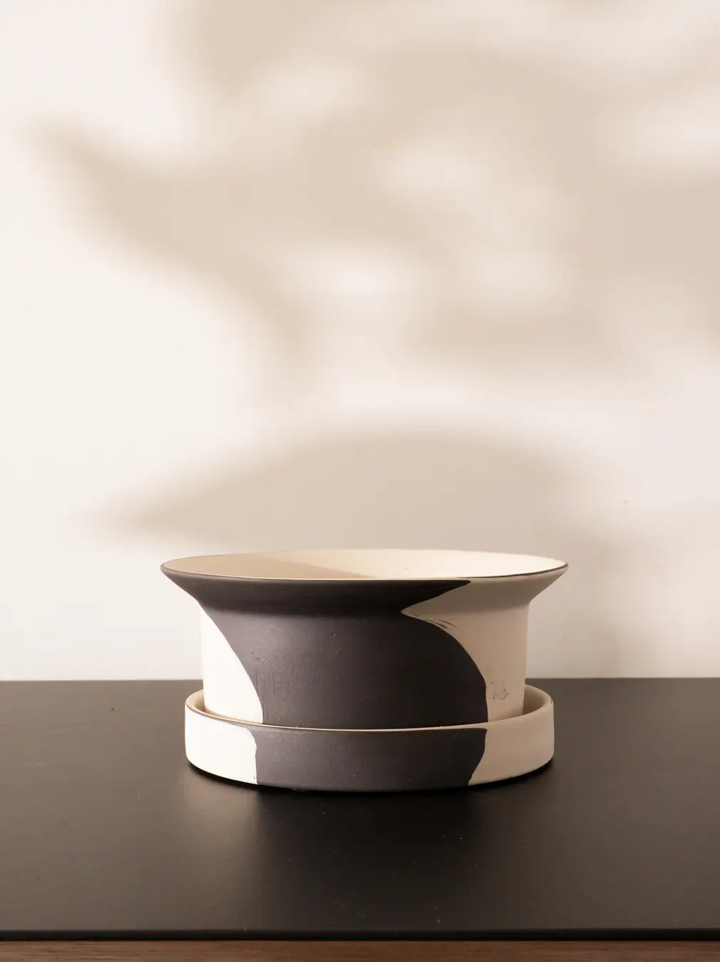 Minimal black and white Kora Ceramic Planter with saucer on dark tabletop