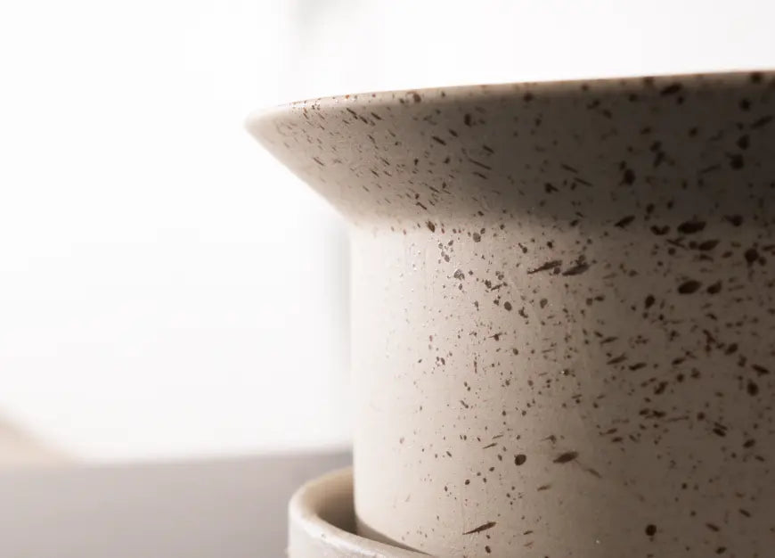 Close-up details of a speckled ceramic pot on a white background