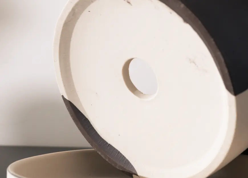 Close-up of ceramic pot base showing drainage hole for healthy plant growth