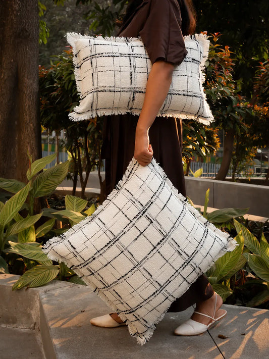 Lattice cushion cover with textured grid design and soft frayed edges outdoors.