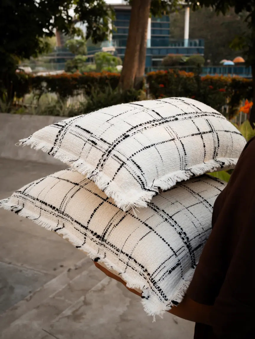 Lattice cushion cover with textured grid and soft frayed edges in natural light.