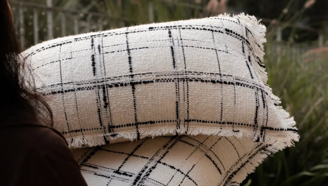 Soft woven cushion cover with frayed edges styled for a warm, minimal living space.