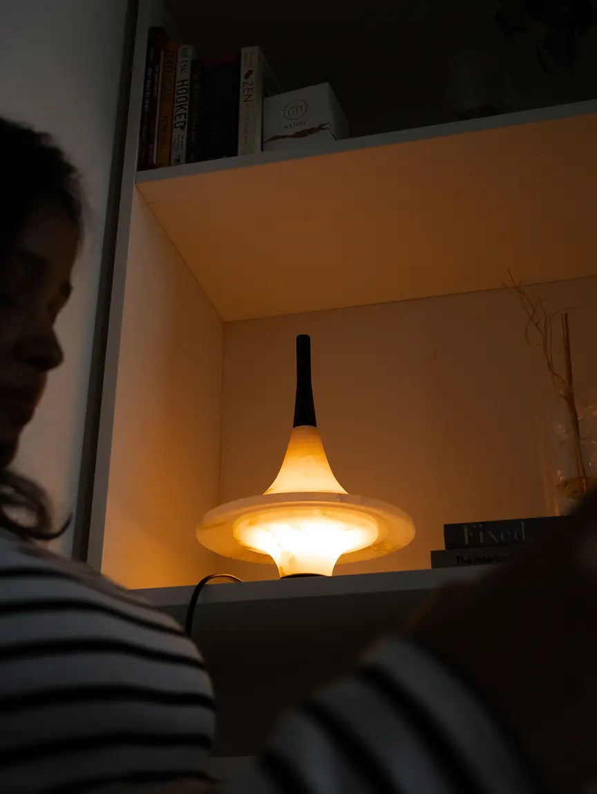 Gharko Lattu Marble Table Lamp styled on bookshelf with warm glow