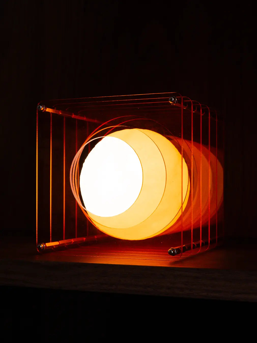 Lop portable table lamp with layered acrylic frame and warm LED glow on shelf